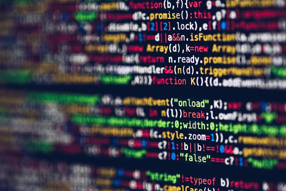 Close-up image of a computer screen displaying lines of code with colorful syntax highlighting in shades of green, pink, blue, and orange. The screen features a dark background typical of coding envir